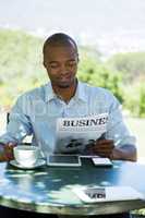 Businessman reading business newspaper at restaurant