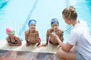 High angle view of female swimming trainer teaching students