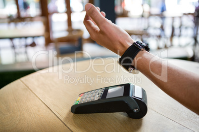 Man using smart watch to express pay in coffee shop
