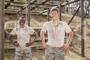 Military man standing with hand on hip during obstacle course in boot camp
