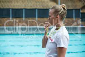 Female lifeguard whistling at poolside
