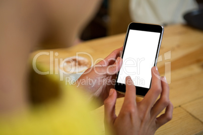 Woman using mobile phone at table in coffee shop