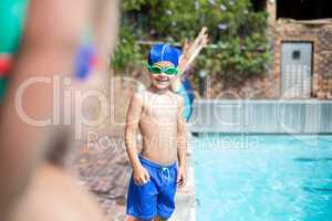 Little boy wearing swimming goggle at poolside