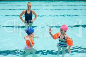 Female instructor and girls in swimming pool