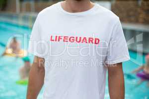 Mid section of lifeguard at poolside