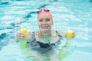 Mature woman swimming with pool noodle