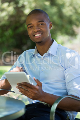 Businessman using tablet PC at outdoor restaurant