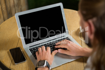 High angle view of man using laptop in coffee shop