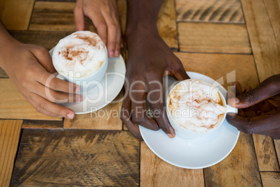 Couple hands holding coffee cups in cafe