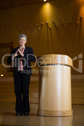 Female business executive gesturing while giving a speech