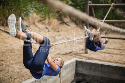 Fit man and woman crossing the rope during obstacle course Fit man and woman crossing the rope during obstacle course