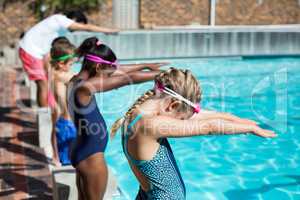 Swimmers with trainer ready to jump in pool