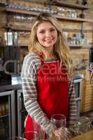 Smiling young female barista at counter in cafeteria