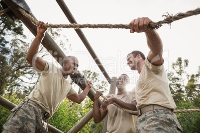 Military soldiers interacting during obstacle training