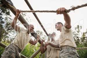 Military soldiers interacting during obstacle training