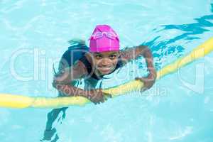 Portrait of girl swimming with pool noodle