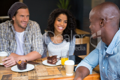 Man talking with friends at table in coffee shop