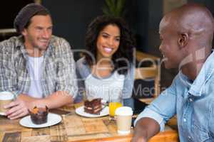 Man talking with friends at table in coffee shop