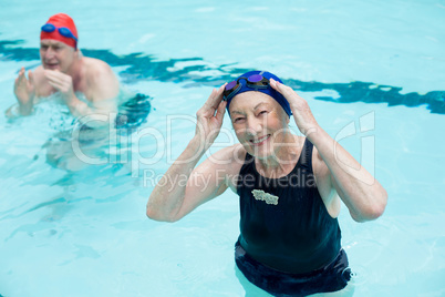 Senior man and woman swimming in pool