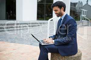 Smiling businessman using laptop