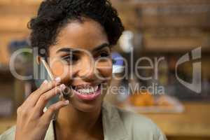 Woman talking on smart phone in coffee shop