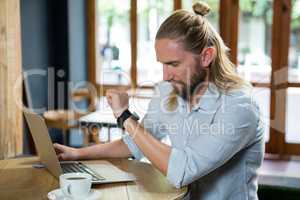 Young man checking time in coffee shop