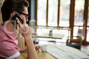 Man talking on mobile phone in coffee shop