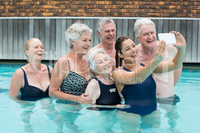 Trainer taking selfie with senior swimmers in pool