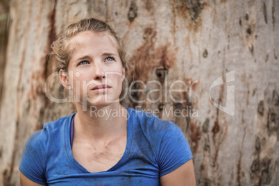 Thoughtful fit woman standing during obstacle course