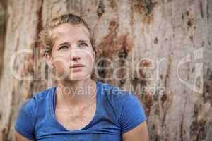 Thoughtful fit woman standing during obstacle course