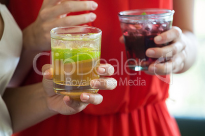 Close-up of women holding drinks at restaurant