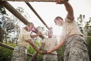 Military soldiers with hands stacked during obstacle training