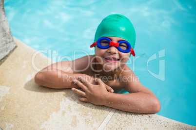 Little happy boy leaning at poolside