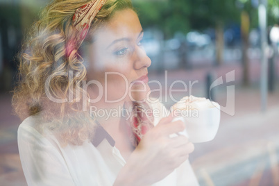 Thoughtful young woman having coffee in cafe