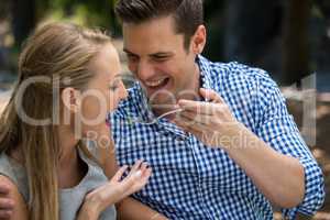 Smiling man feeding woman at outdoor restaurant
