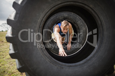 Man crawling through the tire during obstacle course