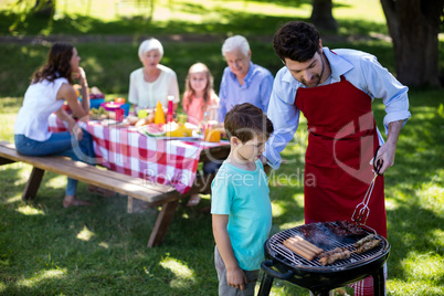 Father and son barbequing in the park
