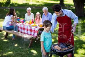 Father and son barbequing in the park