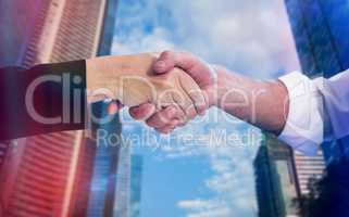 Composite image of business partners shaking hands