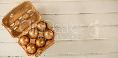Golden Easter eggs in carton