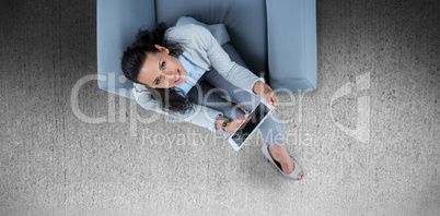 Composite image of woman on her tablet looking up
