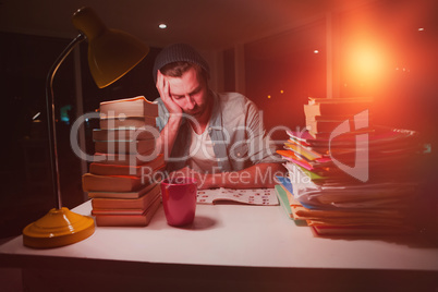 Thoughtful hipster with stacks of books