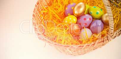 Various Easter eggs in wicker basket