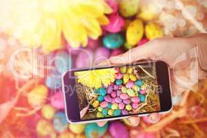 Composite image of hand holding mobile phone against white background