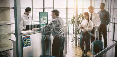 People waiting in queue at airplane counter