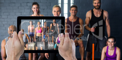 Composite image of cropped hand holding digital tablet