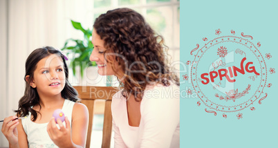 Composite image of happy mother and daughter painting easter eggs