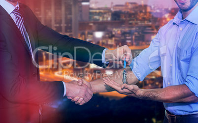 Composite image of smiling businessman giving keys and shaking hands