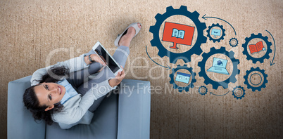 Composite image of woman on her tablet looking up