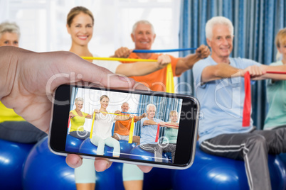 Composite image of hand holding mobile phone against white background